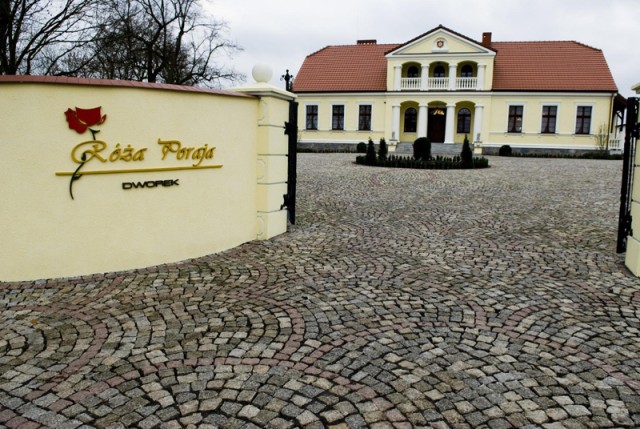 Dworek Róża Poraja z podjazdem wyłożonym kostką granitową w geometryczny wzór wachlarza, brama wjazdowa.